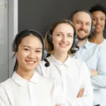 Tim layanan pelanggan yang tersenyum mengenakan headset di kantor siap melayani klien dengan profesional