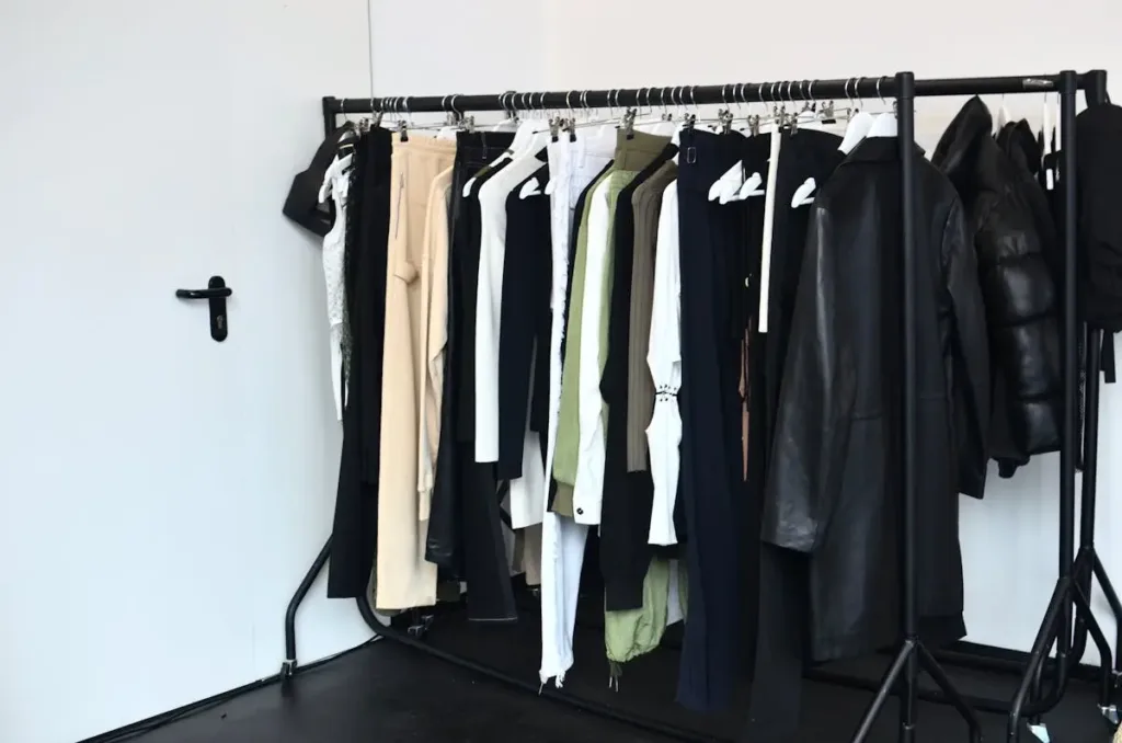 Koleksi pakaian bergaya di gantungan dalam lemari modern