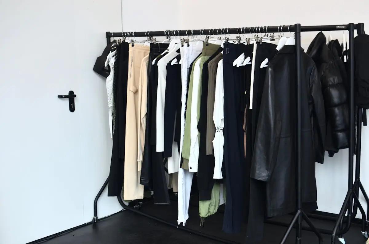 Koleksi pakaian bergaya di gantungan dalam lemari modern